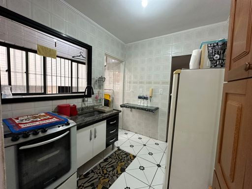 Cozinha com uma pia, gabinete, fogão e geladeira.