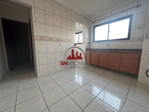 Cozinha com muita iluminação natural e com pia e gabinetes.