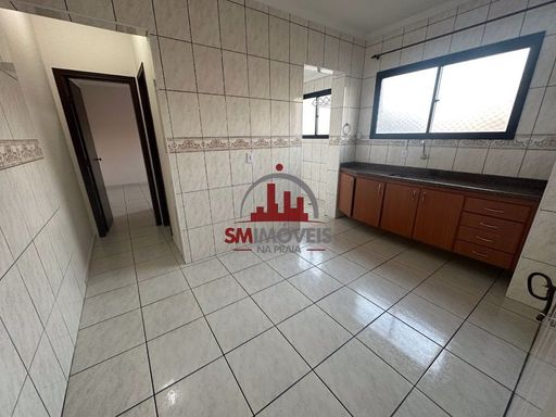 Cozinha com muita iluminação natural e com pia e gabinetes.