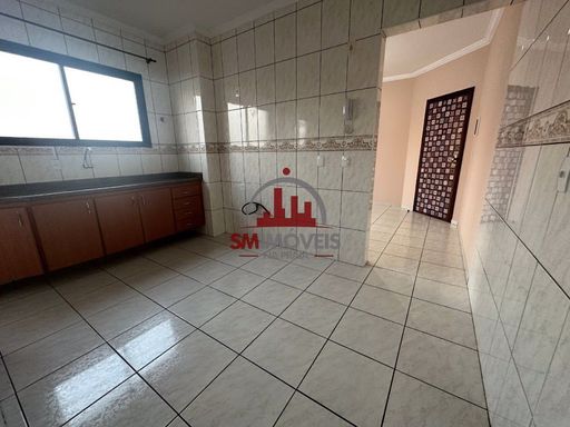 Cozinha com muita iluminação natural e com pia e gabinetes.