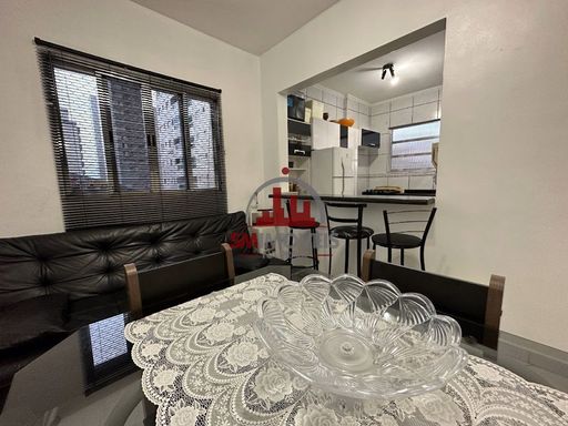Sala com sofá cama e mesa de jantar.