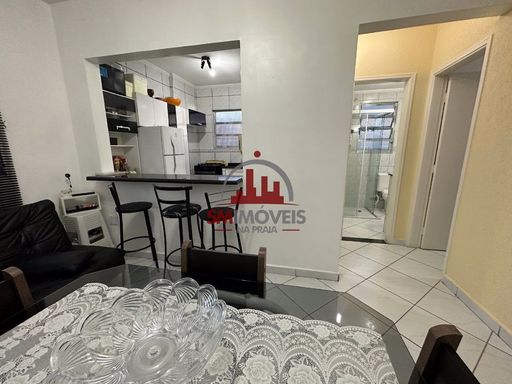 Sala com sofá cama e mesa de jantar.