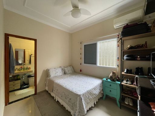 Suíte iluminada com ar-condicionado e ventilador de teto.