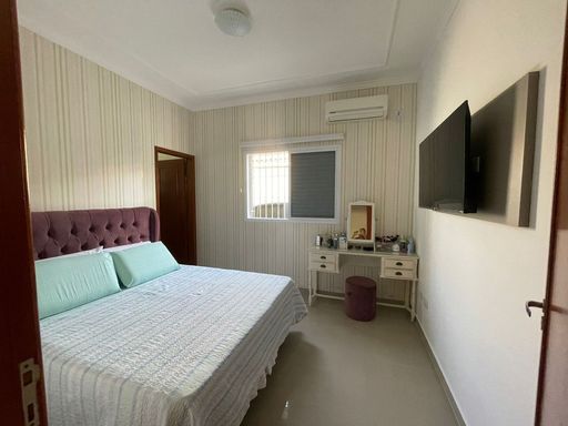 Suíte iluminada com ar-condicionado e ventilador de teto.