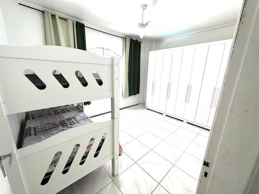 Dormitório espaçoso e bem iluminado com um beliche e ventilador de teto.