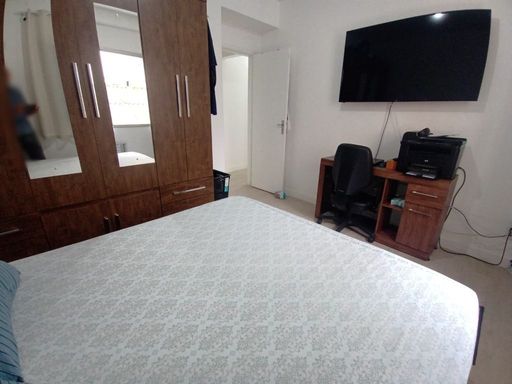 Dormitório com 1 cama de casal e mesa de escritório, e guarda-roupa.