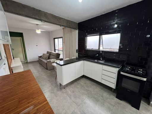 Cozinha americana muito bem iluminada com armários.