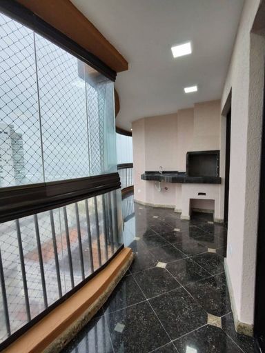 Sacada gourmet envidraçada com vista para o mar.