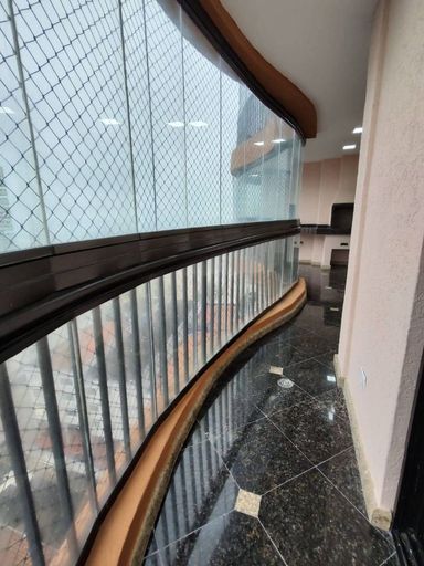 Sacada gourmet envidraçada com vista para o mar.