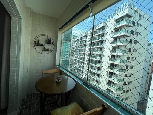 Sacada envidraçada com vista para o mar.