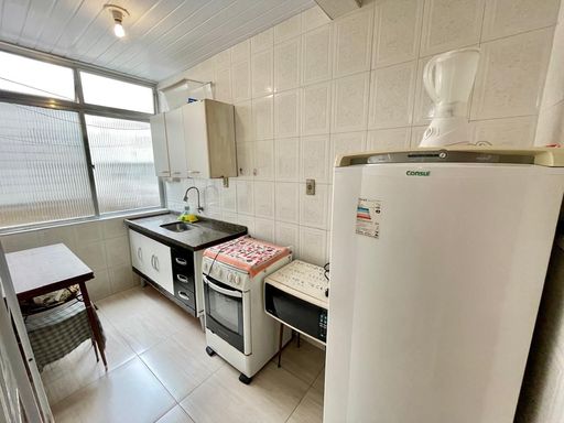 Cozinha com pia, gabinete, fogão e geladeira.