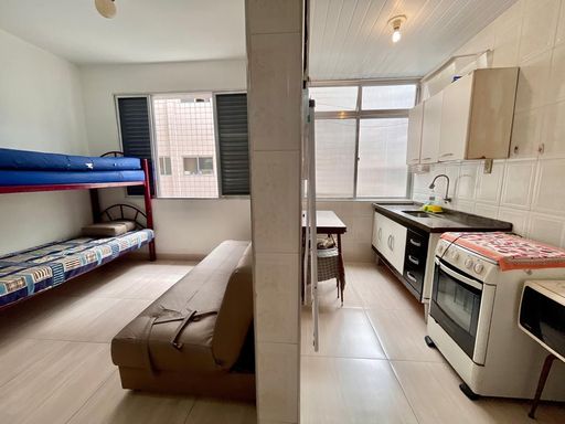 Sala living com muita iluminação natural com ventilador de teto e  Cozinha com pia, gabinete, fogão e geladeira.