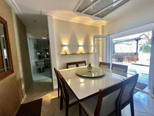 Sala bem iluminada de 2 ambientes com ar-condicionado, ventilador de teto e mesa de jantar.