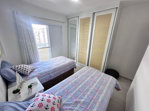 Dormitório solteiro com 2 camas decorado com planejados e iluminação integrado com sacada