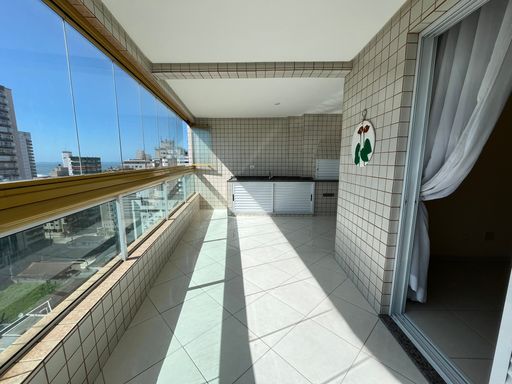 Sacada envidraçada com vista para o mar.