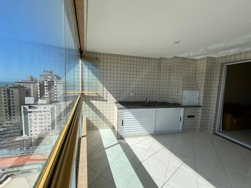 Sacada envidraçada com vista para o mar.