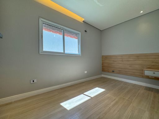 Dormitório com teto rebaixado em gesso com iluminação em LED e armários planejados.
