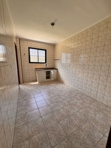 Cozinha espaçosa e bem iluminada com uma pia.