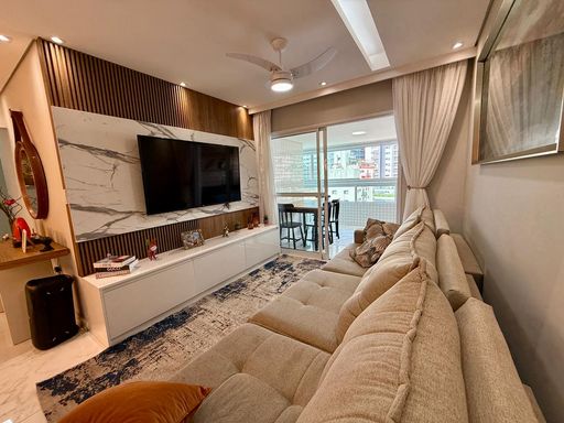 Sala ampla de 2 ambientes com mesa de jantar e um sofá.