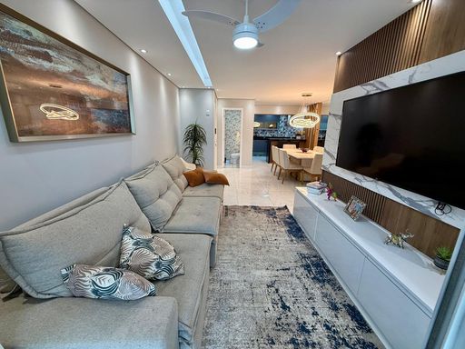 Sala ampla de 2 ambientes com mesa de jantar e um sofá.