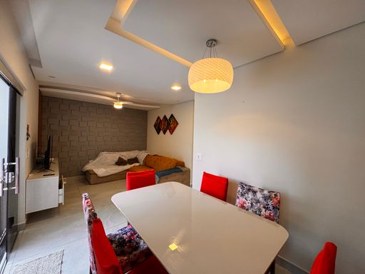 Sala ampla de 2 ambientes com mesa de jantar e teto rebaixado em gesso com iluminação em LED.