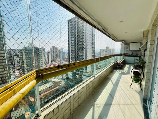 Sacada gourmet envidraçada com vista para o mar.