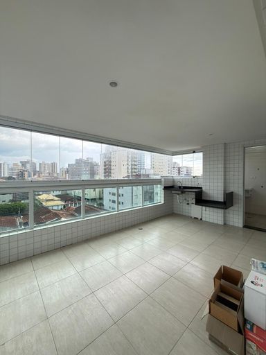 Sacada gourmet envidraçada com vista para o mar.