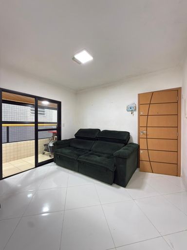 Sala bem iluminada com um sofá e sacada.