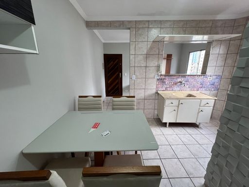 Cozinha americana com mesa de 4 lugares e ventilador de teto.