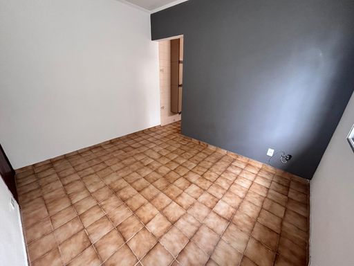 Sala bem iluminada com uma janela grande e parede cinza.