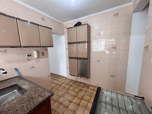 Cozinha bem iluminada com uma pia, gabinete e fogão.