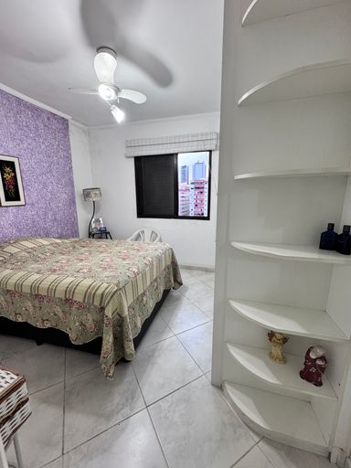 Suíte com 1 cama de casal com ventilador de teto e armários planejados.