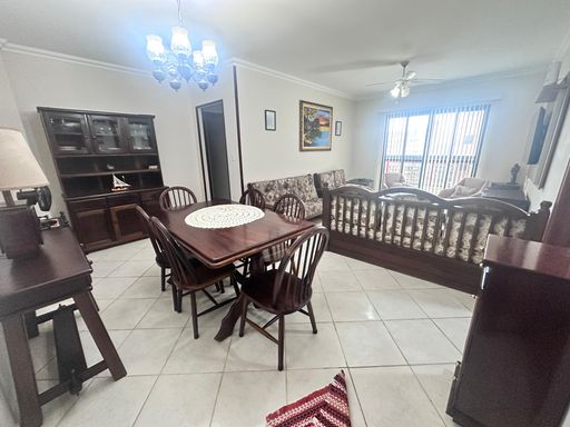Sala de dois ambientes muito bem iluminado com mesa de jantar, 03 sofás, dois poltronas e sacada.