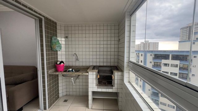 Sacada gourmet envidraçada com vista para o mar.