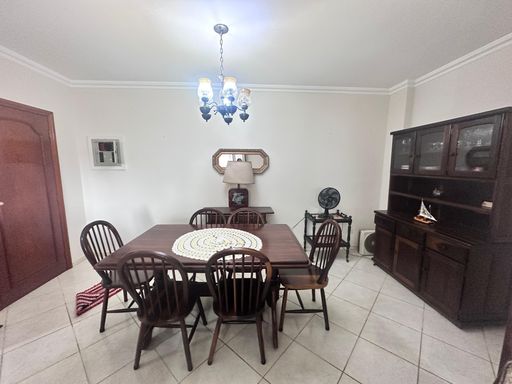 Sala de dois ambientes com mesa de jantar para seis pessoas.