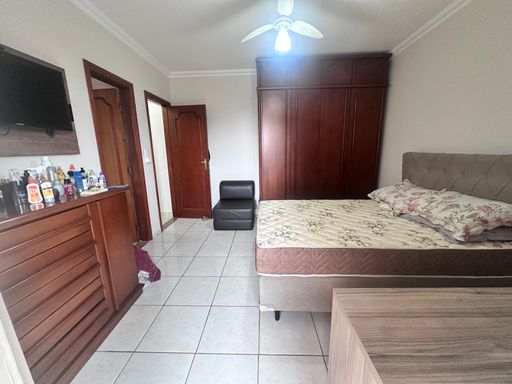 Suíte espaçosa com uma cama de casal, guarda-roupa e sacada privativa.