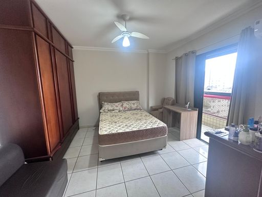 Suíte espaçosa com uma cama de casal, guarda-roupa e sacada privativa.