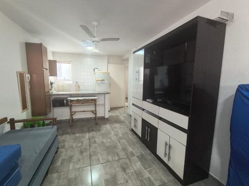 Sala living bem iluminada com ventilador de teto.
