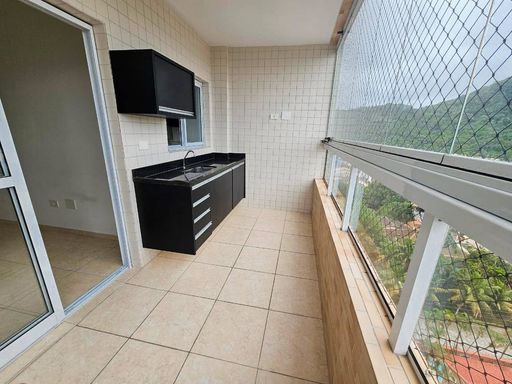 Sacada envidraçada com vista para o mar.