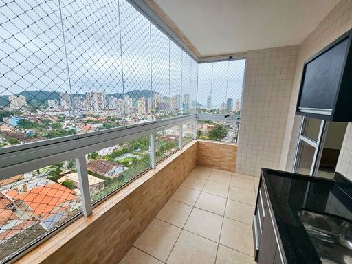 Sacada envidraçada com vista para o mar.