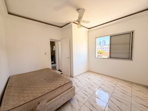 Dormitório amplo e bem iluminado com ventilador de teto.