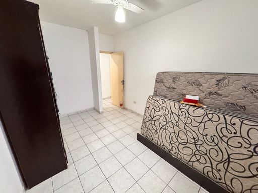 Dormitório muito bem iluminado com uma guarda-roupa e ventilador de teto.