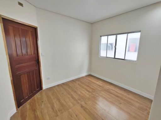 Sala reformada com uma janela grande e piso laminado.