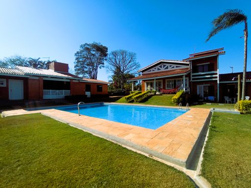 Área externa ampla, piscina e gramado bem cuidado em frente à casa sede.