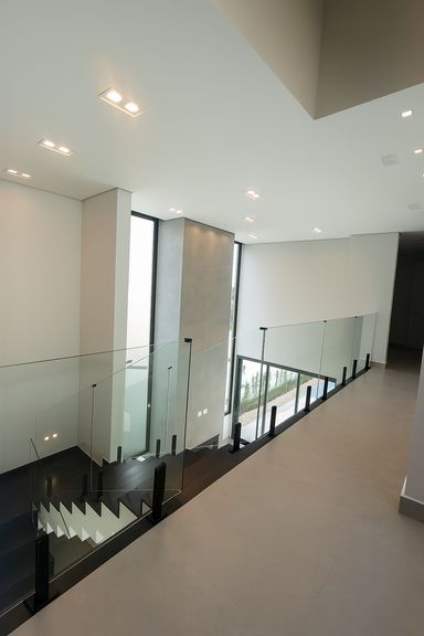 Ambiente integrado com pé-direito duplo, lareira e revestimentos em Portinari, garantindo conforto e elegância