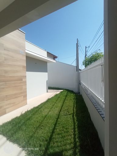 Corredor lateral com jardim e acesso à área de serviço