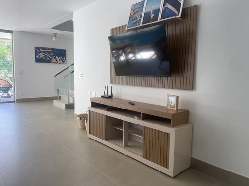 O hall de entrada da casa, com um aparador elegante e espelho.