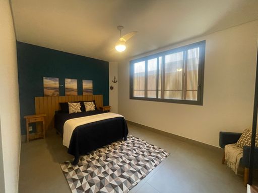 A suíte master, com cama espaçosa e decoração clean.