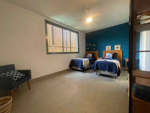 Bem-vindo à suíte perfeita para receber. Com uma decoração neutra e convidativa, este quarto é um convite ao relaxamento. As grandes janelas de vidro trazem a beleza do exterior para dentro, garantindo que seus hóspedes se sintam em casa.