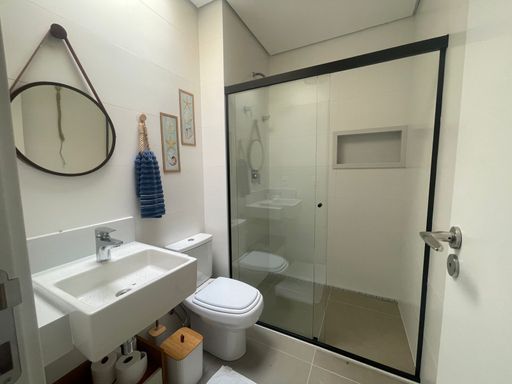 O banheiro da segunda suíte, com chuveiro e design moderno.